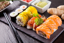 Obrazy i plakaty Delicious sushi pieces served on black stone