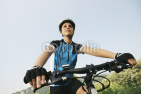 Naklejki young woman training on mountain bike and cycling in park
