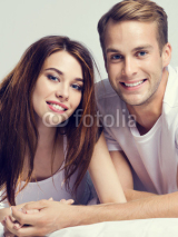 Young attractive happy couple on the bed