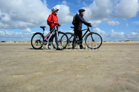 Naklejki Paar mit dem Fahrrad am Sandstrand