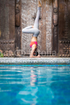 Naklejki Asia woman doing yoga beside swimming pool