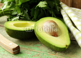 Fototapety ripe avocado cut in half on a wooden table