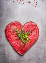 Obrazy i plakaty Heart shape raw meat with herbs and text on gray concrete background , top view, vertical