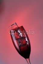 Naklejki Glass with ice cubes on color background