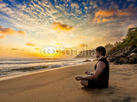 Obrazy i plakaty Young fit man do yoga meditation on tropical beach