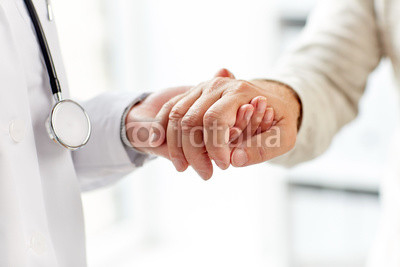 close up of doctor holding old man hand