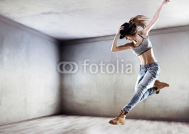 Naklejki Athletic dancer jumping on a concrete wall background