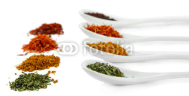 Naklejki Assortment of spices in  white spoons, isolated on white