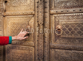 Naklejki Woman opening golden door in Jaipur