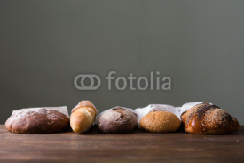 Obrazy i plakaty Fresh baked bread at wooden table