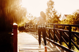 Fototapety Beautiful female jogger running during sunset