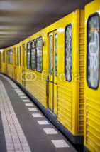 Fototapety Yellow metro in subway station. Berlin, Germany.