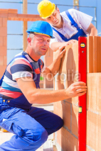 Naklejki Bauarbeiter bauen Haus auf Baustelle