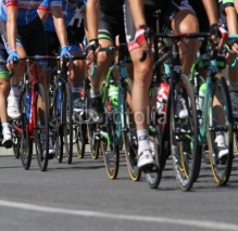 Fototapety Group of cyclists ride uphill vigorously during the cycling race