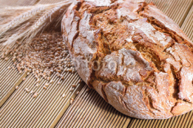 Obrazy i plakaty Fresh bread with wheat on the wooden background