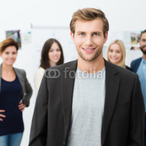 Fototapety junger mann im büro mit team im hintergrund