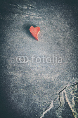 Vintage toned wooden red heart on grunge stone background, shallow depth of field, space for text.