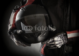 Naklejki Motorcyclist with helmet in his hands. Dark background