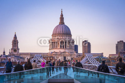 Londoners walking through Millennium Bridge after sunset - London, UK