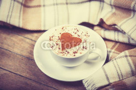 Cup with coffee and scarf.