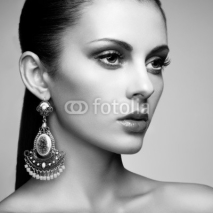 Fototapety Portrait of beautiful young woman with earring. Jewelry and acce
