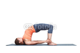 Fototapety Beautiful sporty fit yogi girl practices yoga asana setu bandhas