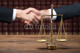 Fototapety Justice Scale On Table With Judge And Client Shaking Hands