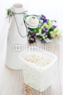 Cottage cheese and milk bottle on the table, selective focus
