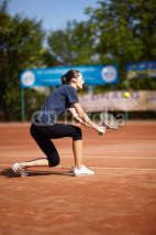 Naklejki Tennis player executing a backhand volley