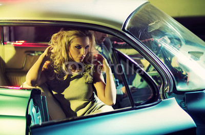 Young alluring couple in the retro car