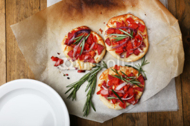Small pizzas on baking paper close up