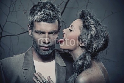 Portrait of a woman licking men's cheek