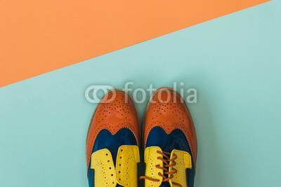 Flat lay fashion set: colored vintage shoes on colored background. Top view.