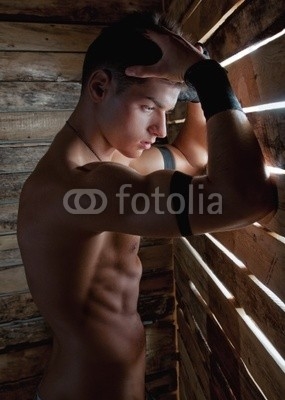 Muscle sexy naked young man near to wooden boards