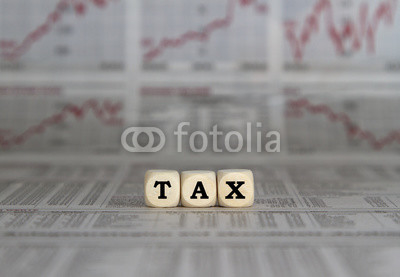 Tax word with calculator on newspaper background