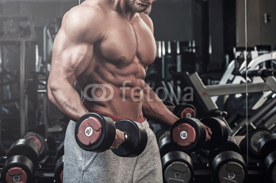 Muscular man doing a exercise for biceps