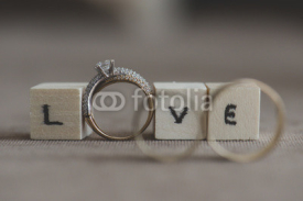 Fototapety Wedding and engagement rings with inscription love