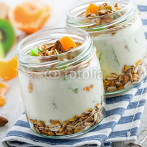 Granola with yogurt and fruits in a rustic jar. Delicious healthy American food for breakfast. Traditional US snack.