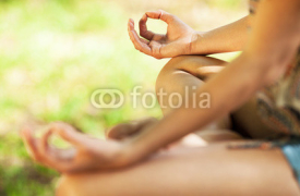 Obrazy i plakaty Young female meditate in nature.Close-up image.