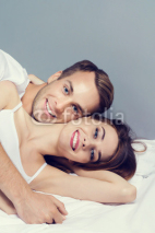 Young attractive happy couple on the bed