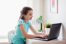 girl typing on laptop at home