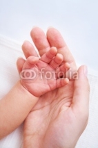 Naklejki Female hand holding newborn baby's hand