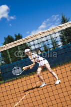 Naklejki Young woman playing tennis