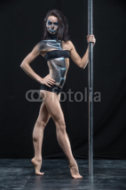 Pole dancer with body-art in dark studio