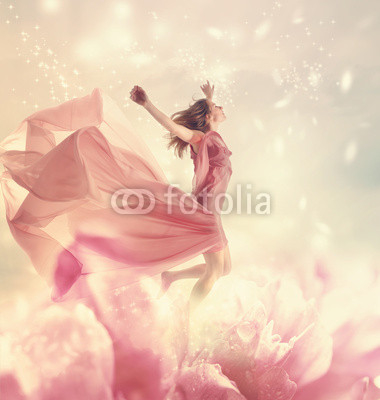 Beautiful young woman jumping on a giant flower