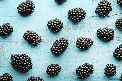 Ripe and sweet blackberries on blue wooden table
