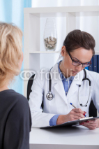 Doctor sitting with the patient and takes notes
