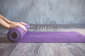 Naklejki Woman rolling her mat after a yoga class
