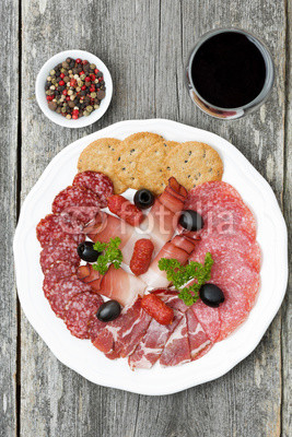 assorted deli meats and a glass of wine, top view