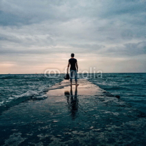 Fototapety Man with a bag stands on a pier